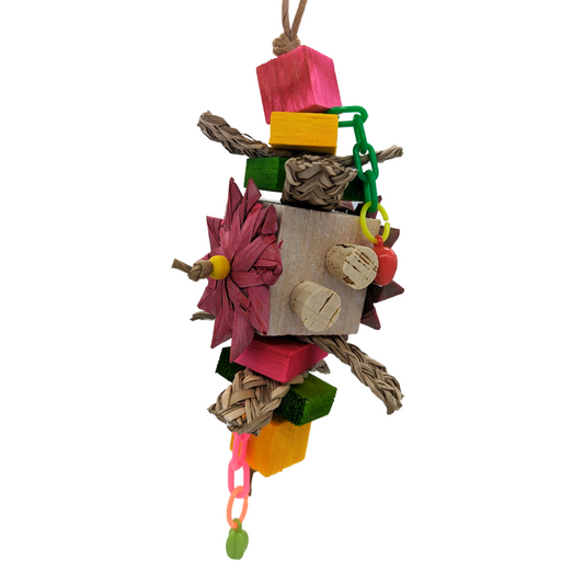 A colorful bird toy made of balsa wood, cork, and seagrass with plastic fruit charms and paper rope.