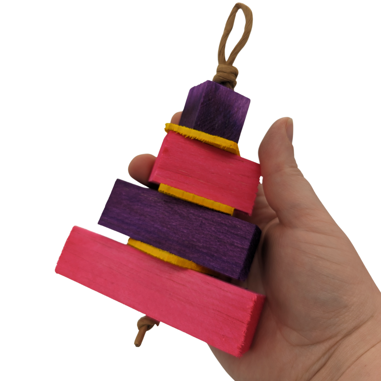 Balsa Birthday Cake by Lil Monsters Bird Toys. Held in hand for scale. Pink and purple color scheme.