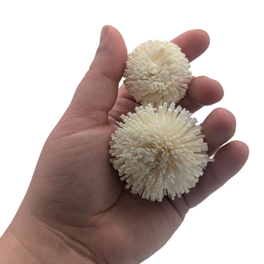 Snowball by Lil Monsters Bird Toys. Shown with a 1.5 inch and 1 inch variation in a hand to show scale.