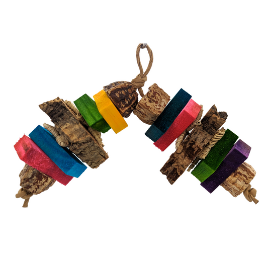 A colorful bird toy made of balsa, cork bark, mahogany, and vine, strung together on a paper rope.