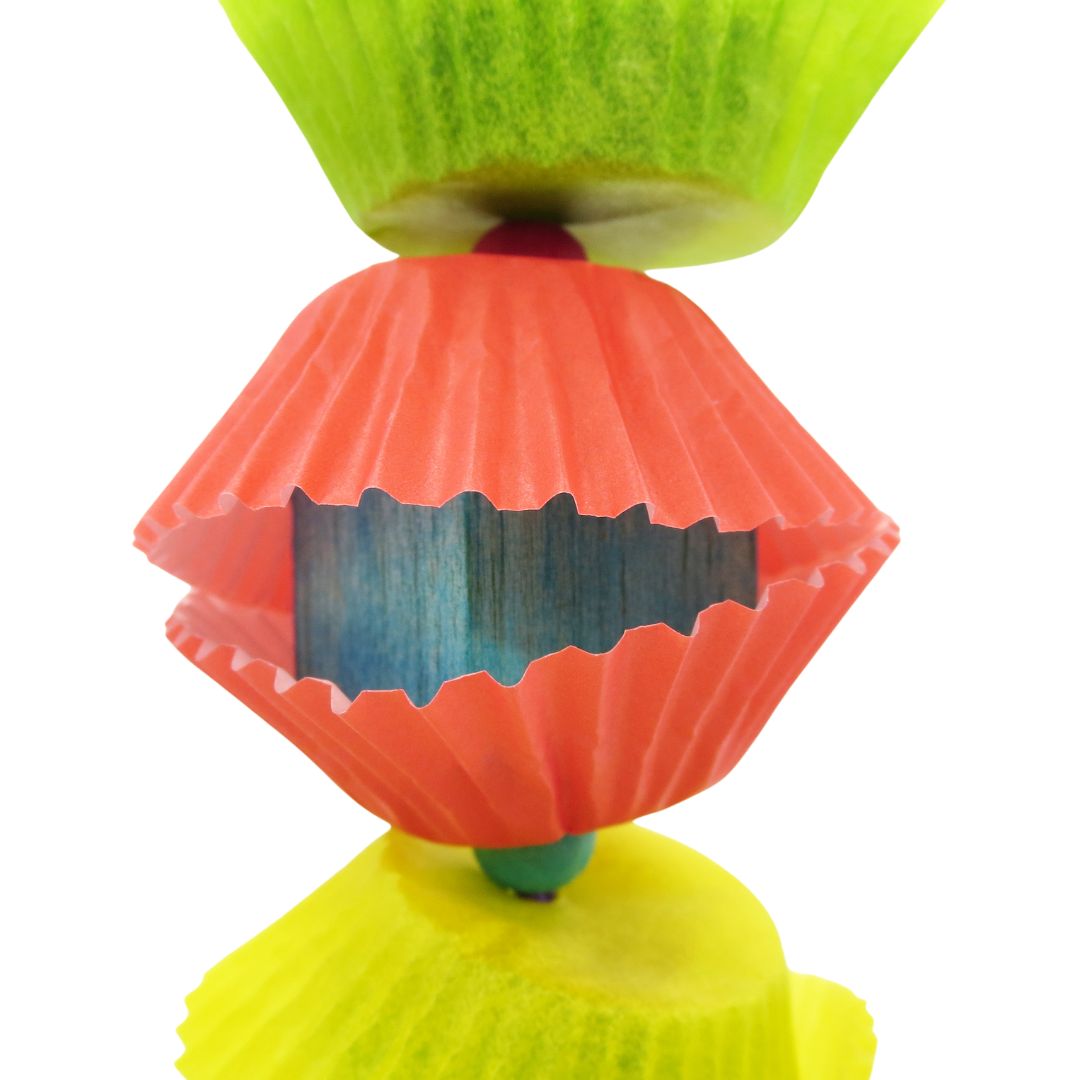 Close up of a 1 inch balsa cube covered in 2 mini cupcake liners