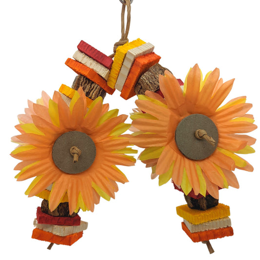 A colorful bird toy made of pine and balsa wood, featuring sunflower-shaped paper cutouts and striped patterns.