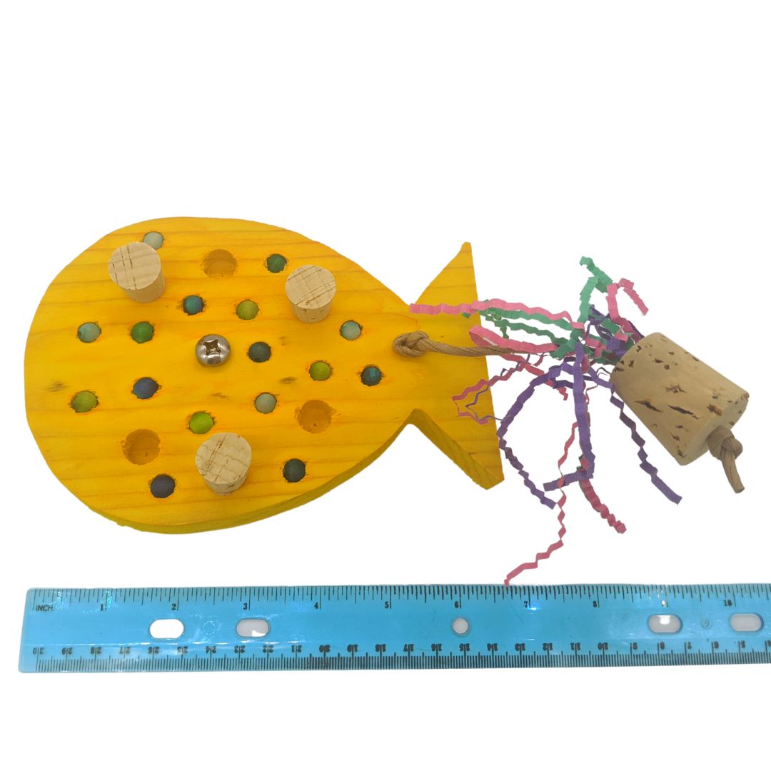 A birthday balloon shaped piece of pine, with embedded corks, wooden beads, and string with cork weight. Shown next to ruler