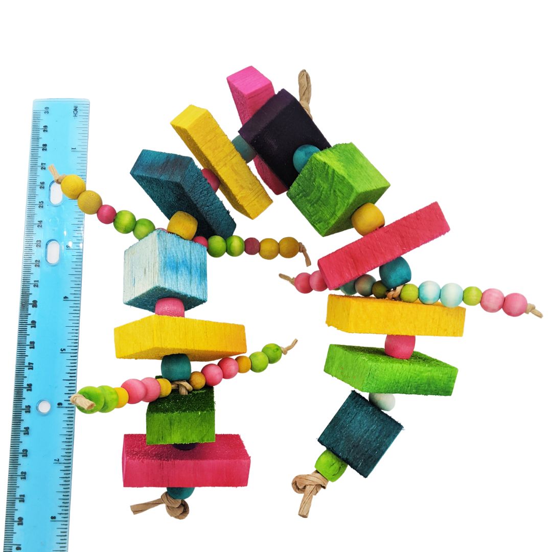 A toy with 10 half inch thick balsa slats, 3 one inch balsa blocks, and 3 sets of wooden beads. Next to ruler for scale