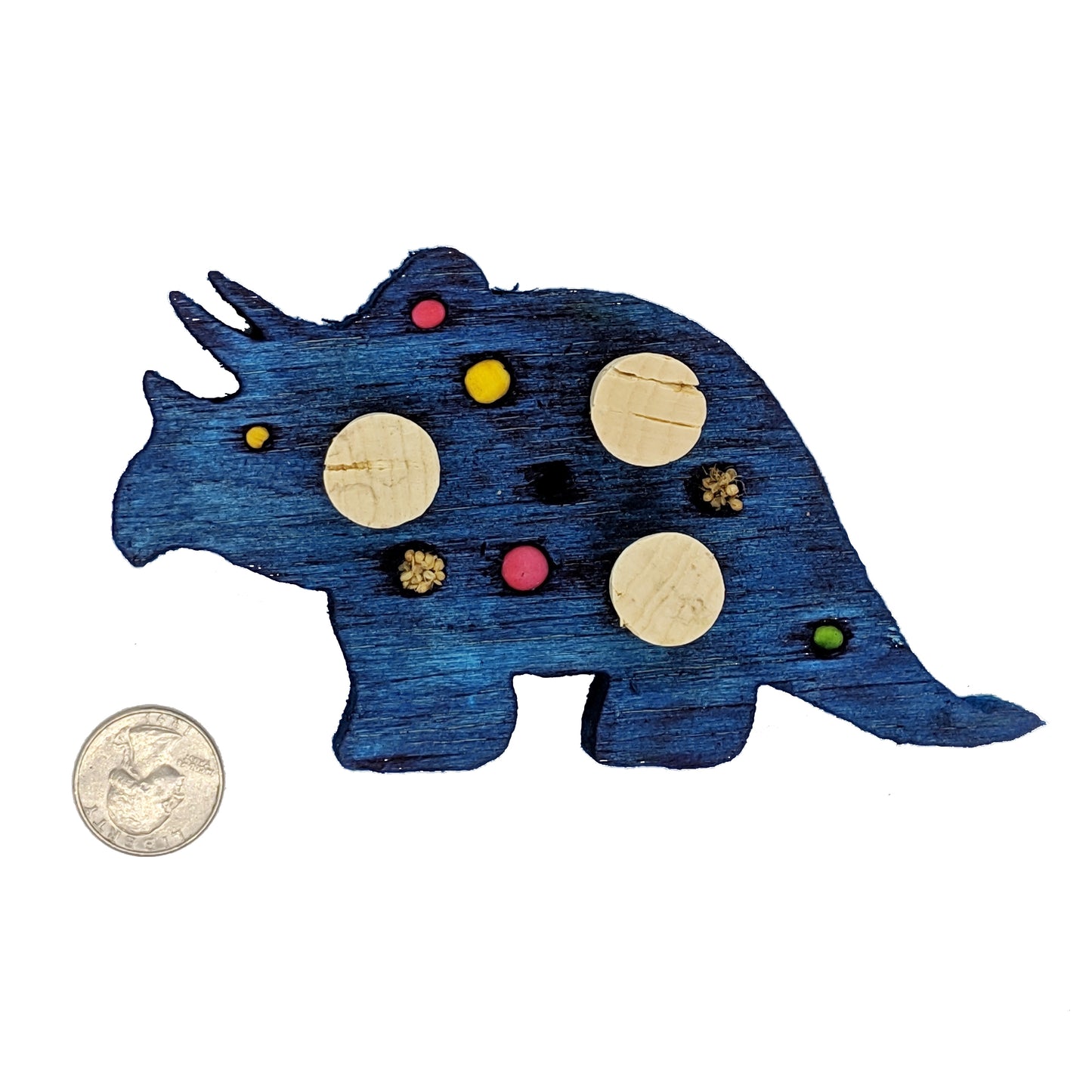 A triceratops shaped piece of balsa, with embedded corks, 4 spots for beads or millets, and 3 smaller beads.