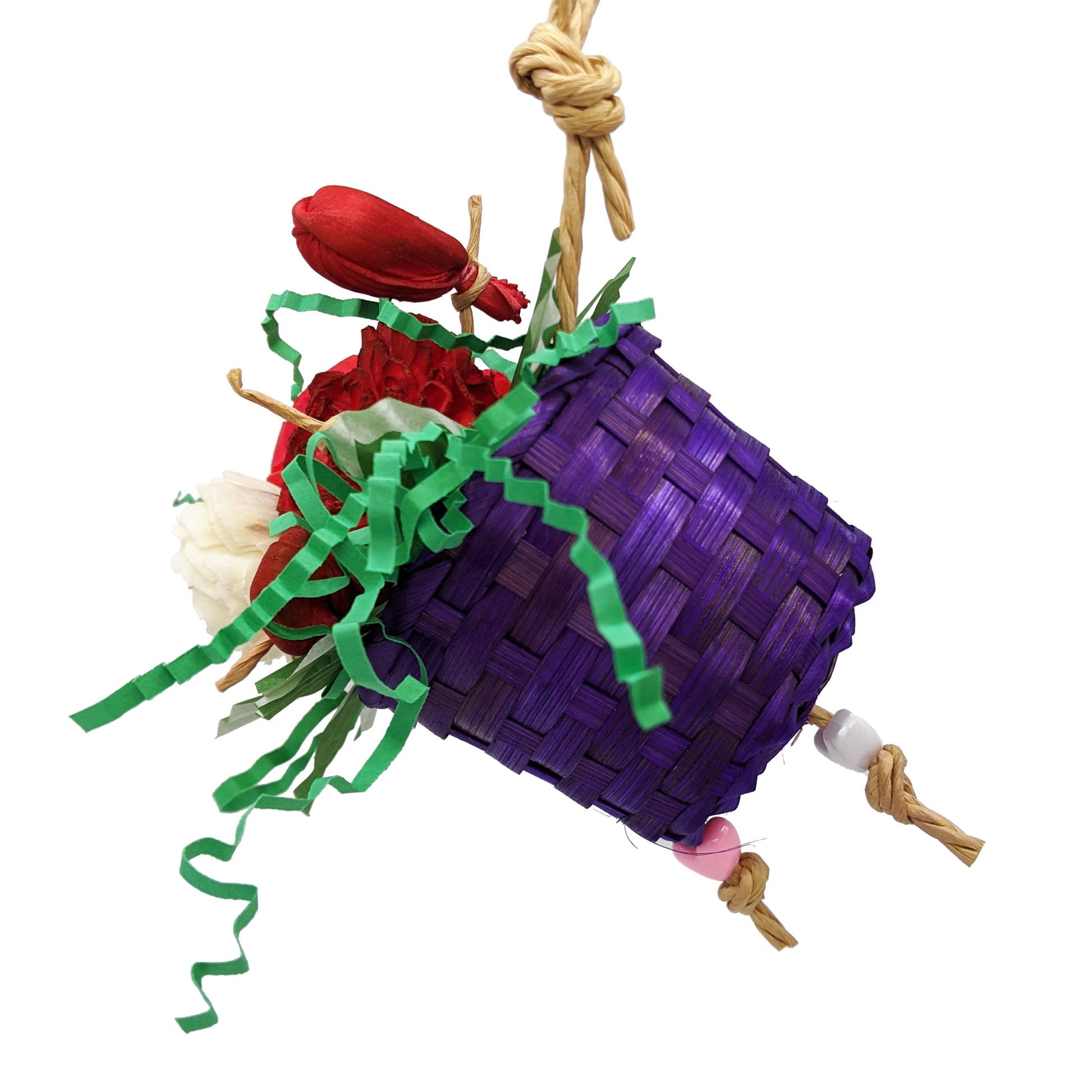 A bird toy with a basket, overflowing with 3 sola flowers dyed red, white, and pink. With shred paper and cupcake liners.