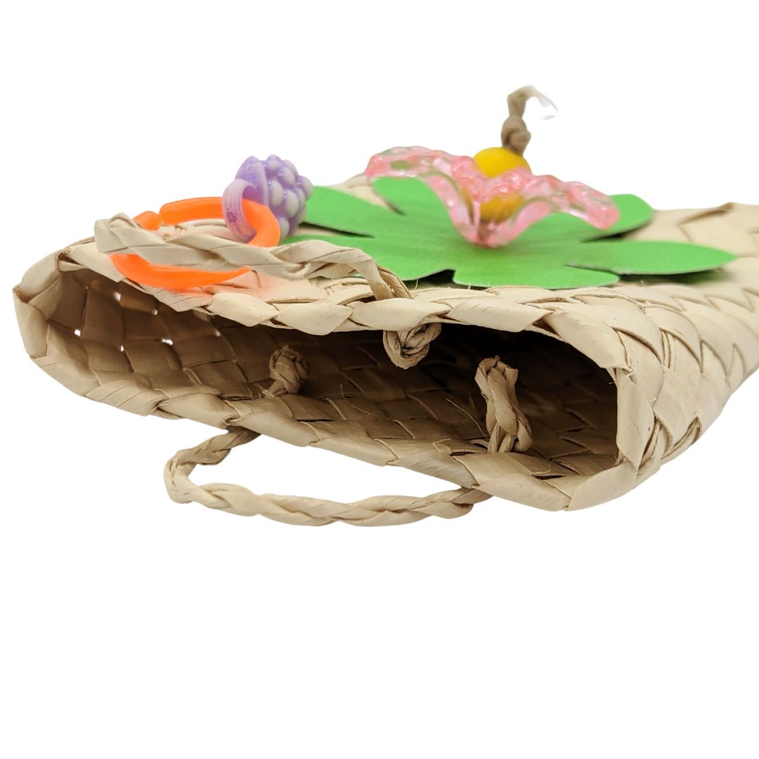 A woven palm bag with cardstock leaves, acrylic flower, and fruit charm.