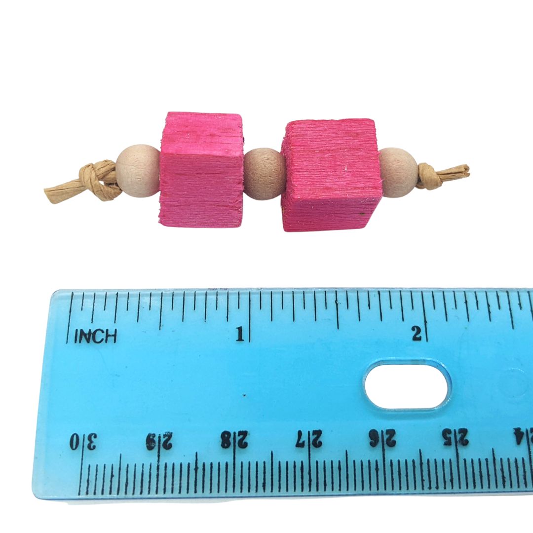A small foot toy composed of three 8mm wood beads separated by two 1/2" balsa blocks. Shown next to ruler showing size at 2" long