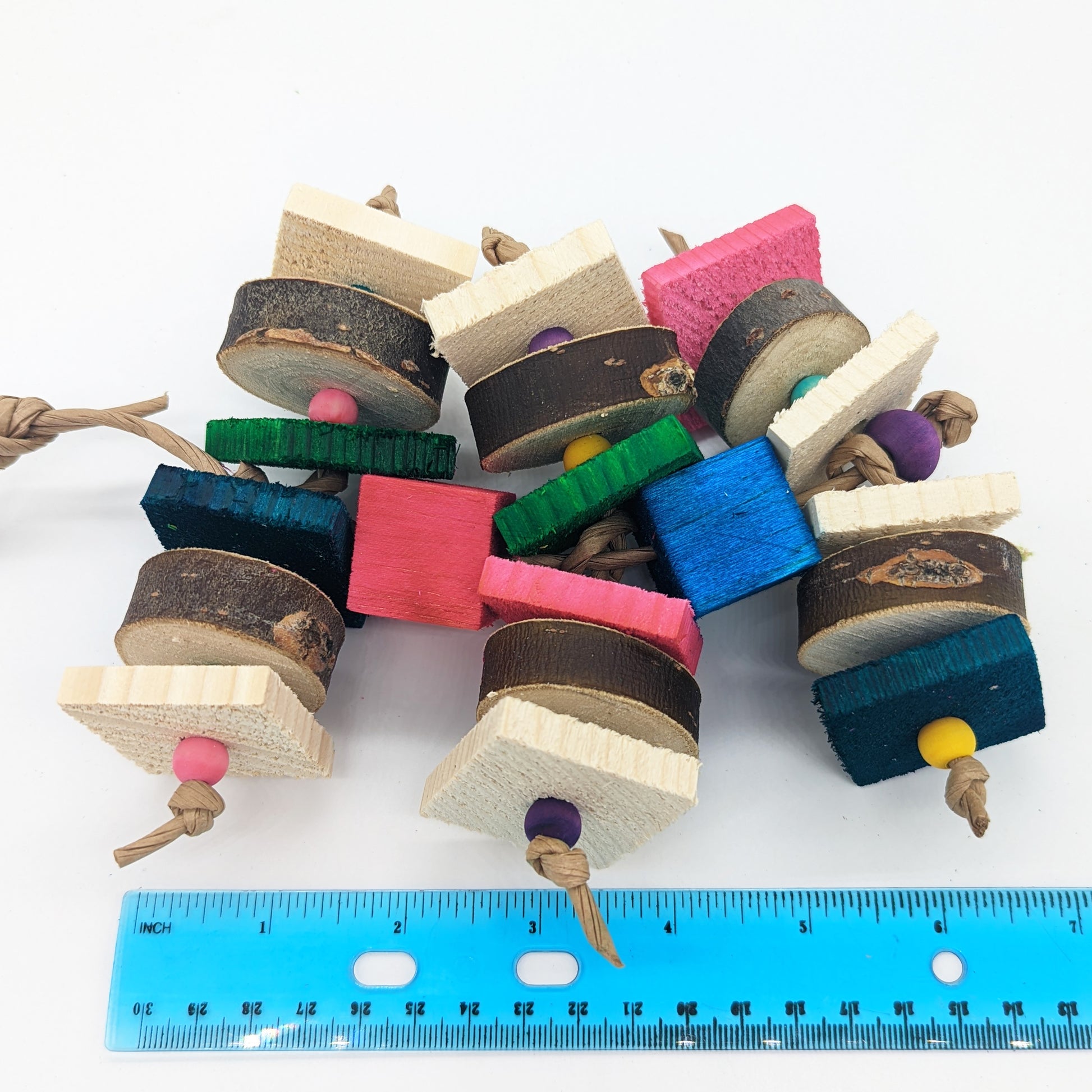 A bird toy for birds that love wood! Alternating pieces of 1/4" thin pine cut against the grain with pieces of natural willow or cottonwood slices. Wooden beads between the slices of wood, and balsa blocks between the levels of the toy.  Shown with a ruler to show its length of about 7".