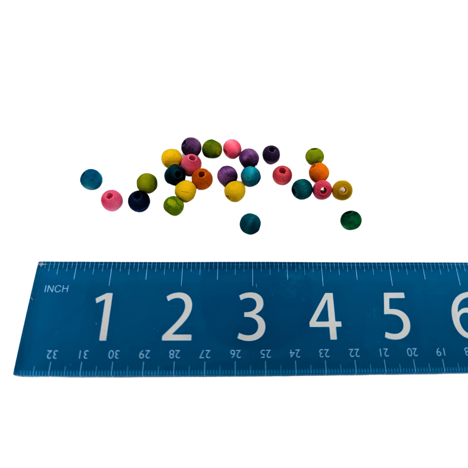 A set of 25 multicolored wood beads measuring 8mm, by Lil Monsters Bird Toys, next to a ruler for scale