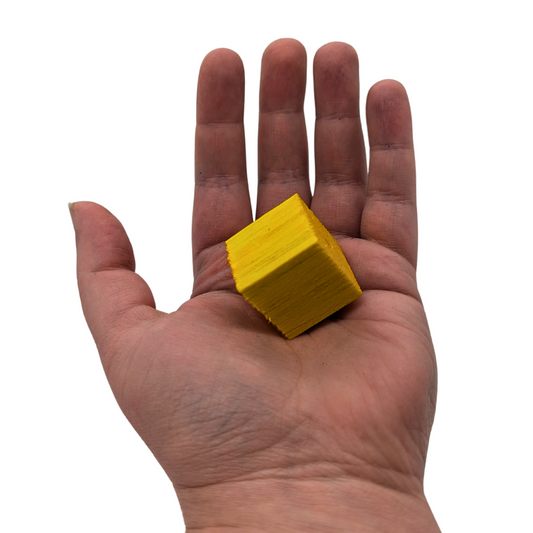 1 inch balsa cubes for making bird toys, one held in hand for scale