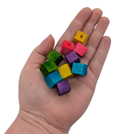 Mini half inch balsa cubes for toy parts, by Lil Monsters Bird Toys, shown in hand for scale