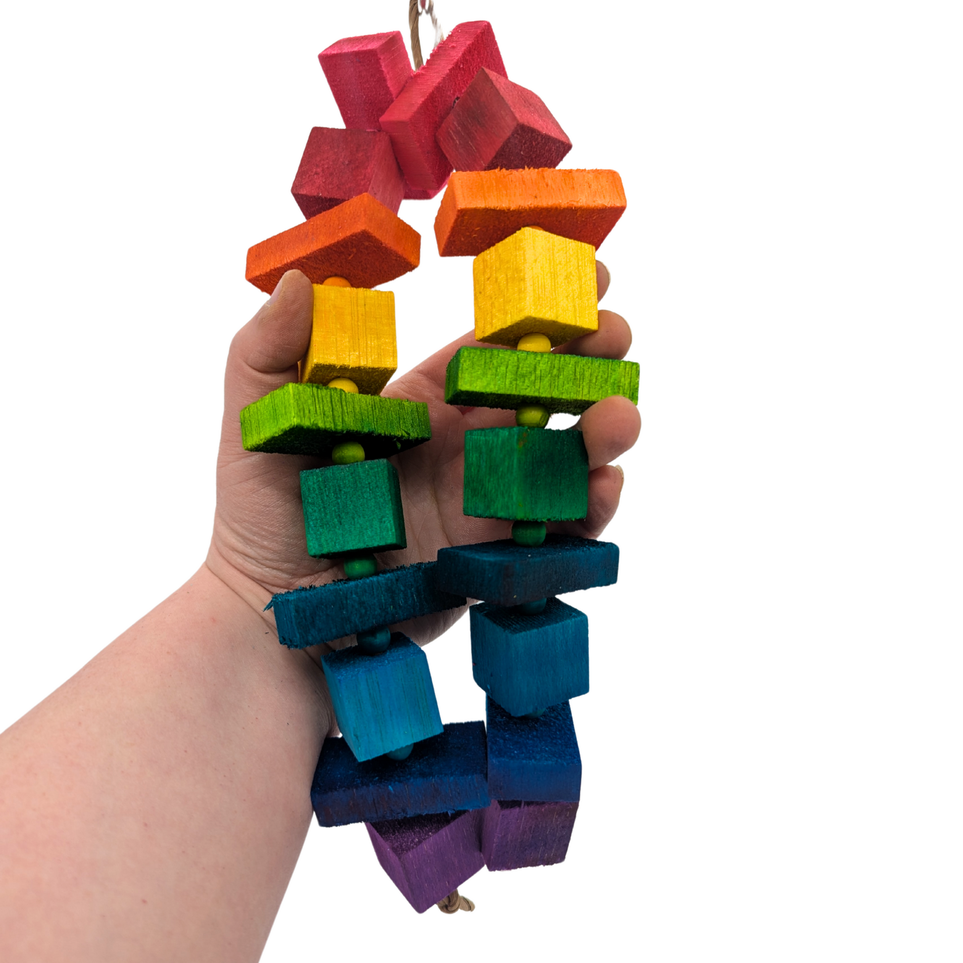 Balsa Rainbow bird toy, dyed the colors of the rainbow, held in a hand for scale. 