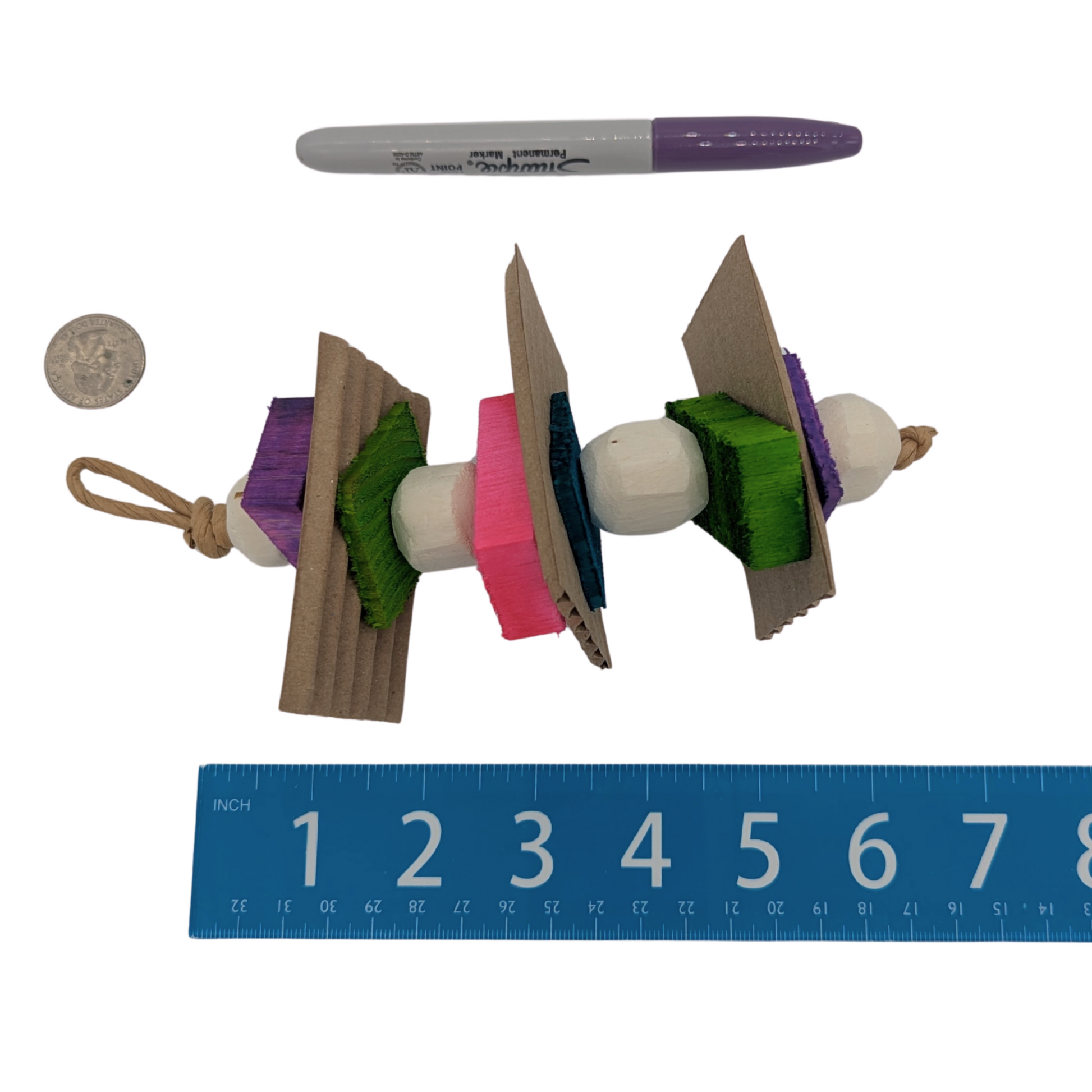 Chickadee Parrot Toy by Lil Monsters Bird Toys, next to a sharpie, ruler, and US quarter for scale