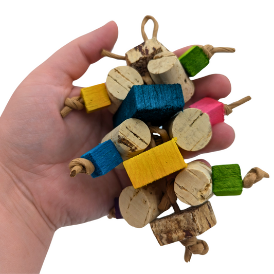 Corky parrot toy by Lil Monsters Bird Toys, with cork stoppers, balsa, and mahogany pods, in hand for scale