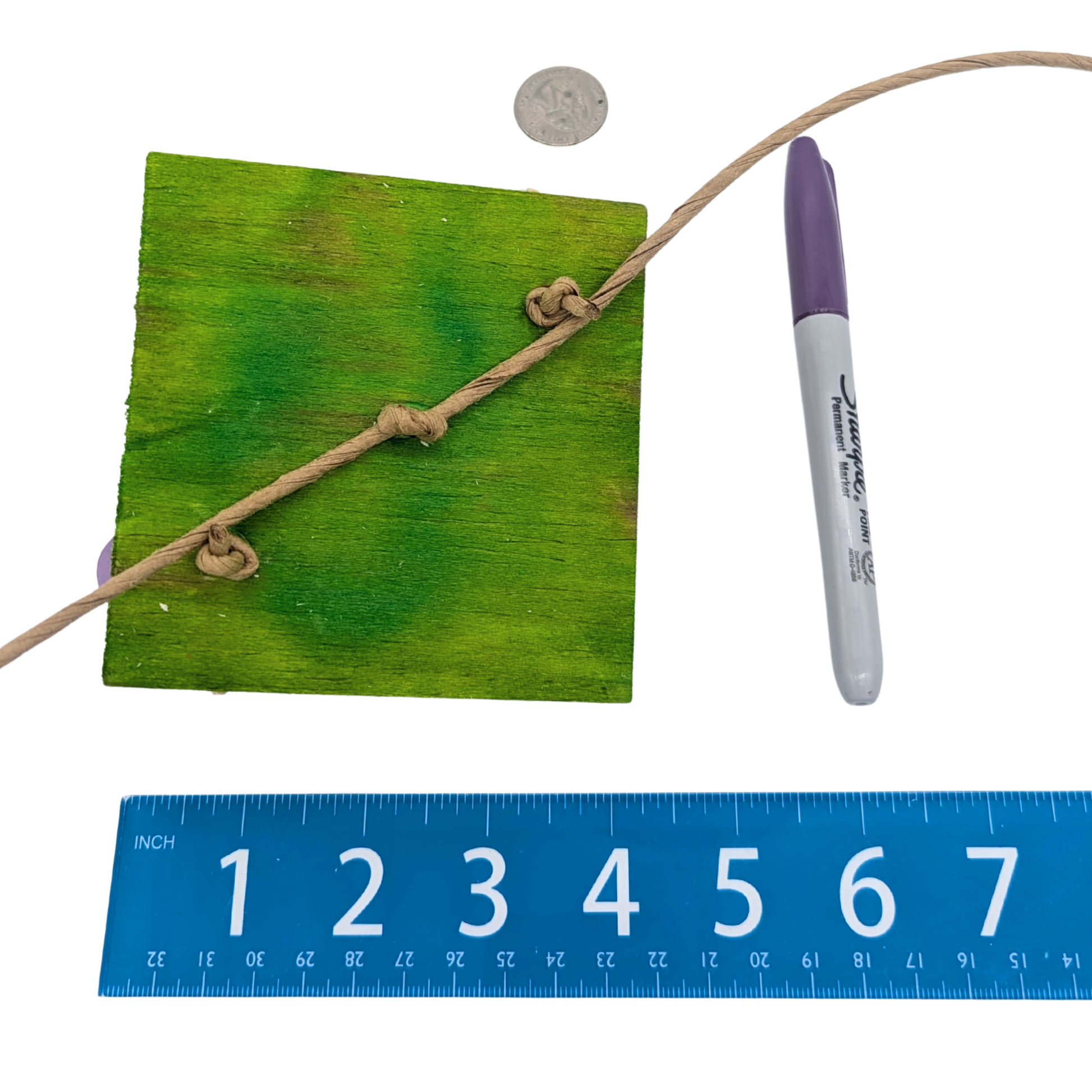 Dandy Parrot toy by Lil Monsters Bird Toys, next to a sharpie, ruler, and US quarter for scale, back view