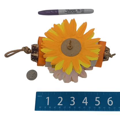 Sunflower-shaped bird toy with a pen, ruler, and coin for scale, on a white background