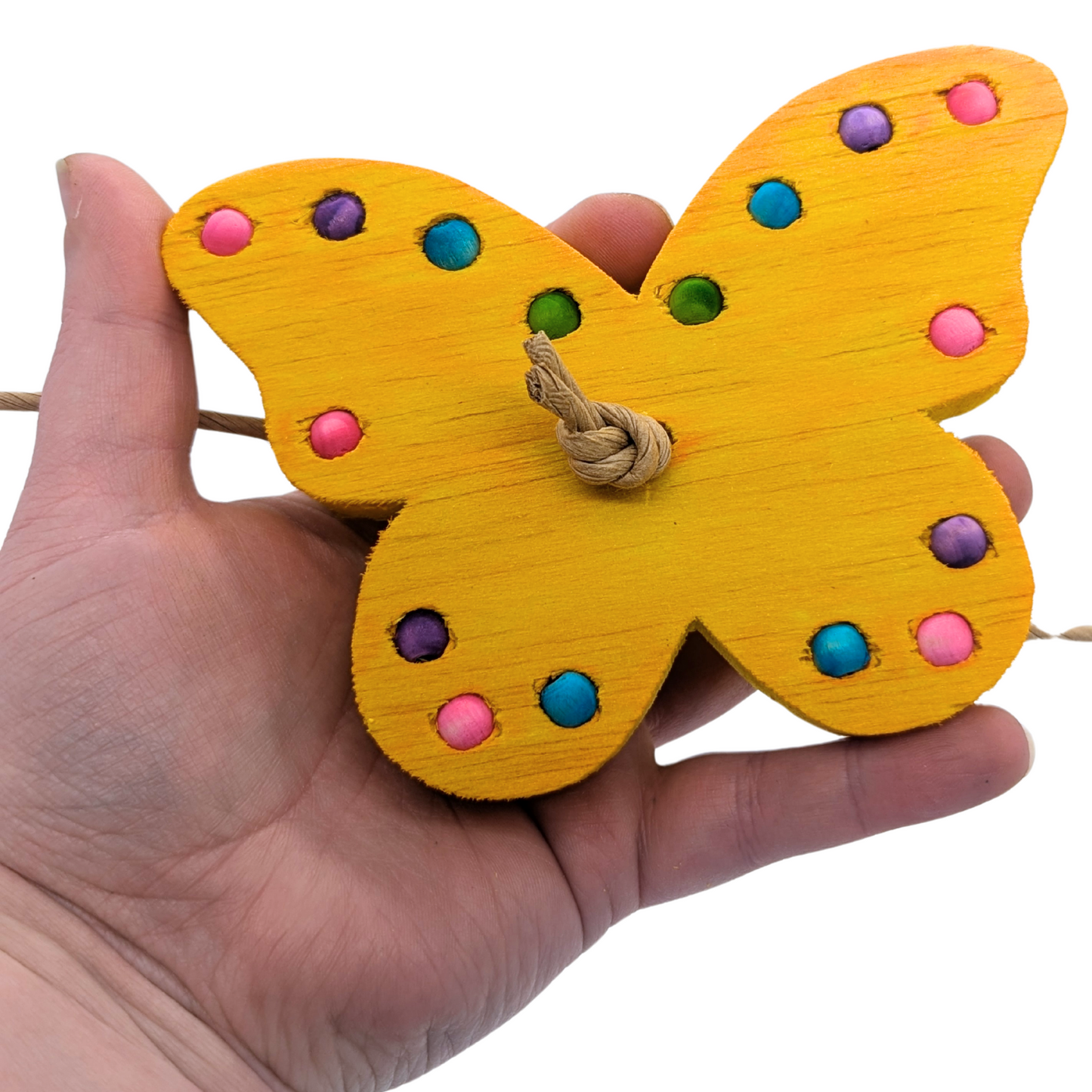 Flutterby balsa bird toy by Lil Monsters Bird Toys, held in hand for scale