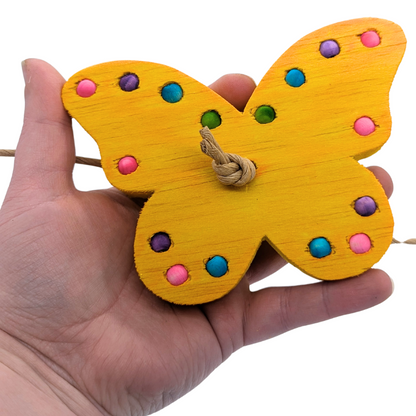 Flutterby balsa bird toy by Lil Monsters Bird Toys, held in hand for scale