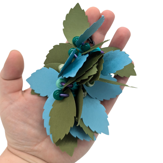 Leaves parrot toy by Tiny Conure Trinkets, held in hand for scale