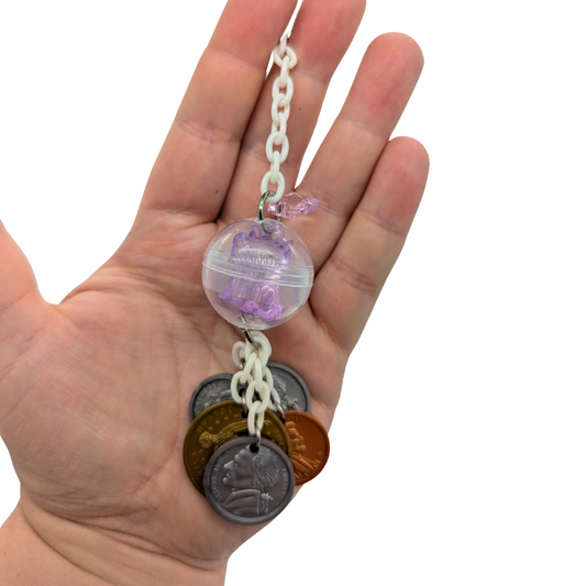 A Maneki Neko bird toy by Tiny Conure Trinkets, held in hand for scale