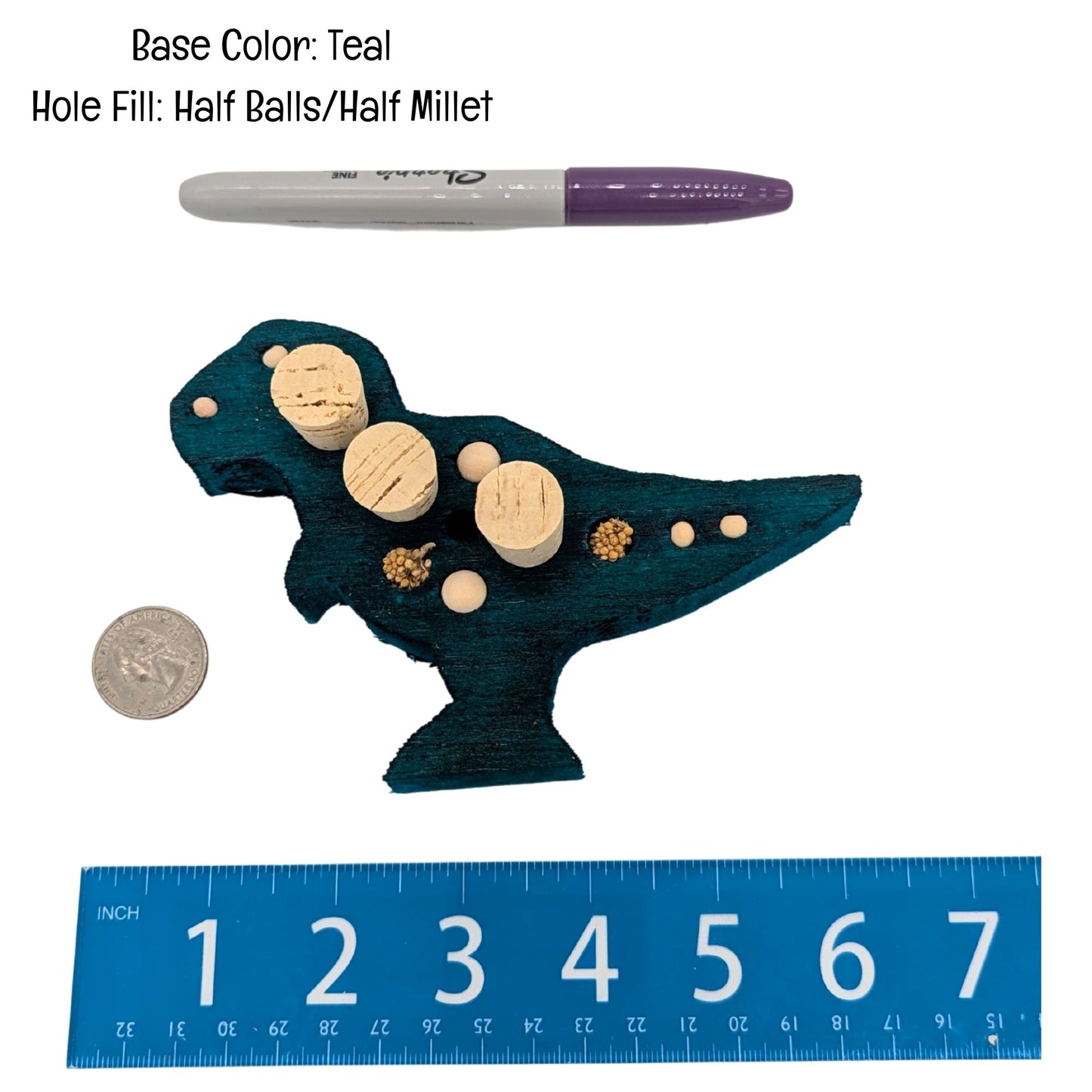 Balsasaurus Rex by Lil Monsters Bird Toys. A piece of balsa cut into the shape of a t-rex dinosaur. Embedded with cork stoppers, millet, and wooden beads. Shown next to a US quarter, sharpie marker, and ruler for scale. 