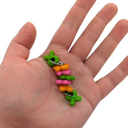 Bunny Twister foot toy for birds by Tiny Conure Trinkets, held in hand for scale