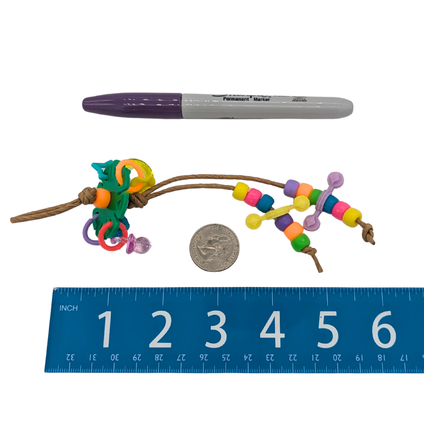 Fidget by Lil Monsters Bird Toys. Shown next to a ruler, US quarter, and Sharpie marker for scale. 