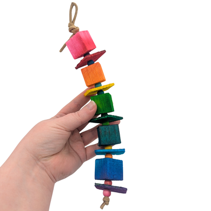 Hugh by Lil Monsters Bird Toys. A linear, 8mm bead variant, held in hand for scale. 