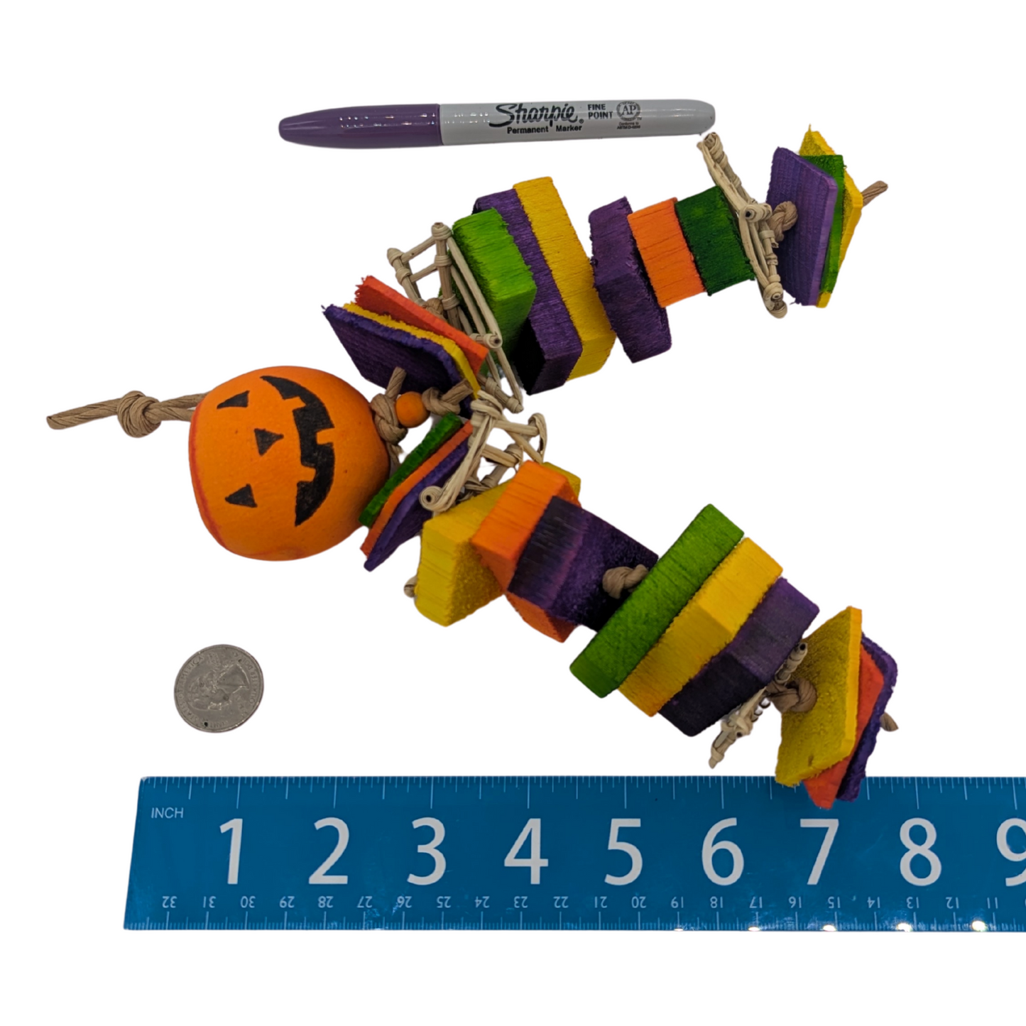 Ichabod Halloween parrot toy by Lil Monsters Bird Toys, next to a sharpie, ruler, and US quarter for scale
