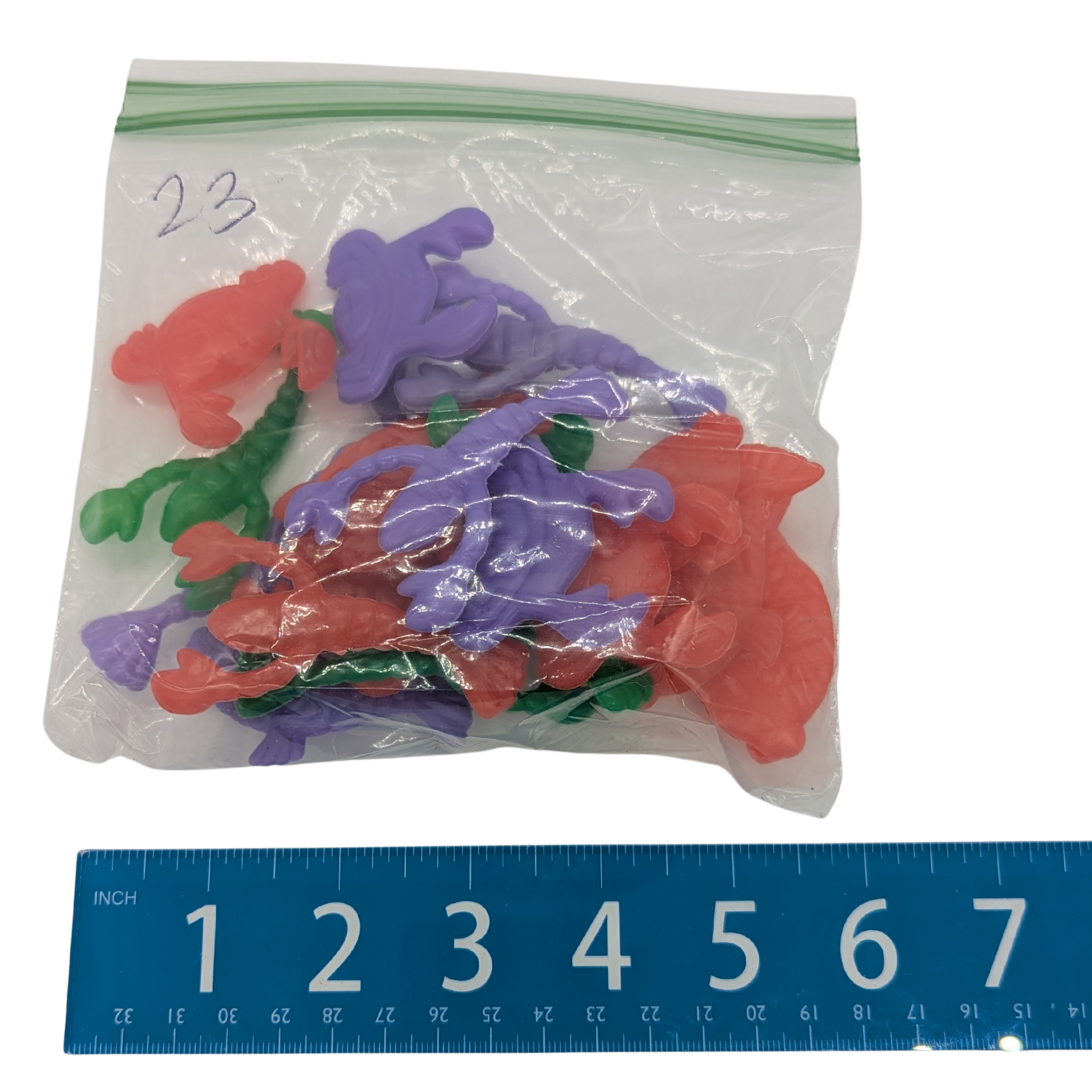 Bag of 23 Sea Creature bird toy parts by Lil Monsters Bird Toys, next to ruler for scale