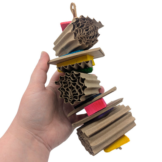 Ripple by Lil Monsters Bird Toys. Made up of corrugated cardboard rolls, alternating with thin pine and balsa slices. Held in hand for scale. 