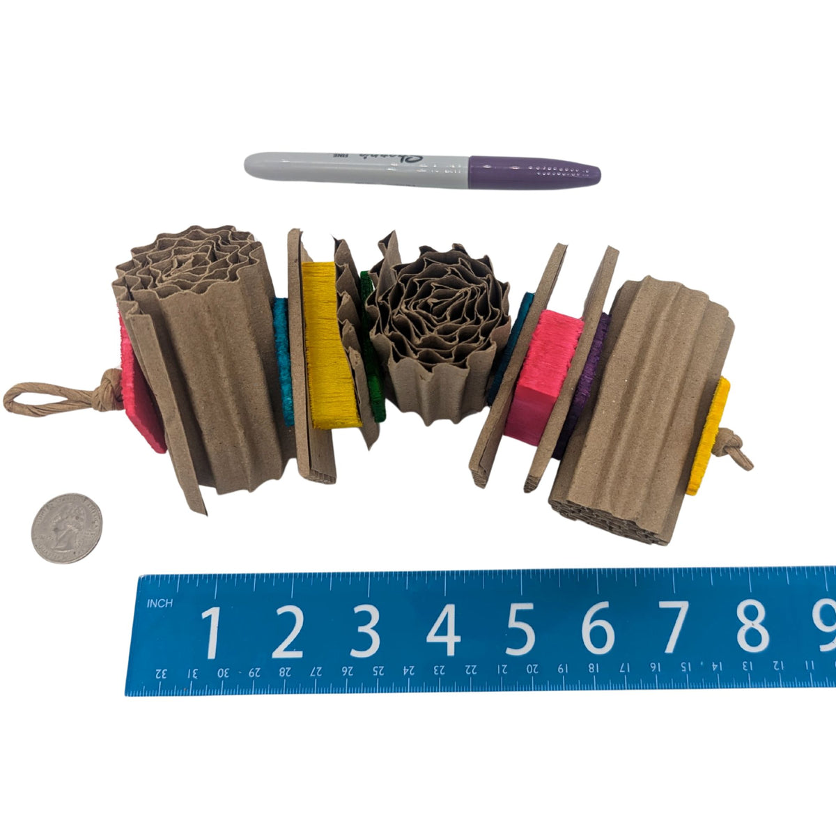 Ripple by Lil Monsters Bird Toys. Made up of corrugated cardboard rolls, alternating with thin pine and balsa slices. Shown next to a US quarter, sharpie marker, and ruler for scale. 