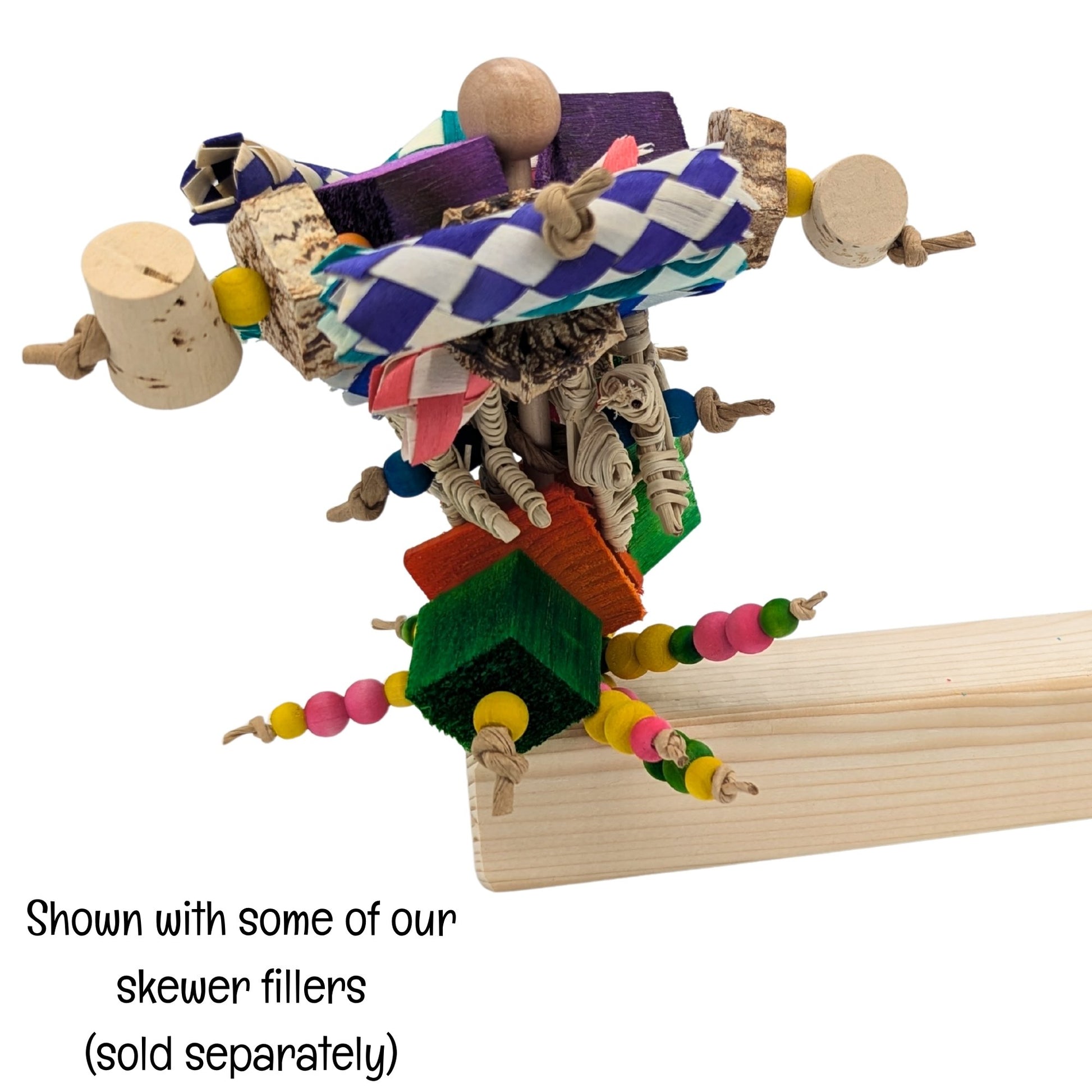 Skewer Perch by Lil Monsters Bird Toys. It is filled with various toy texture. Caption on image says "Shown with some of our skewer fillers (sold separately). 
