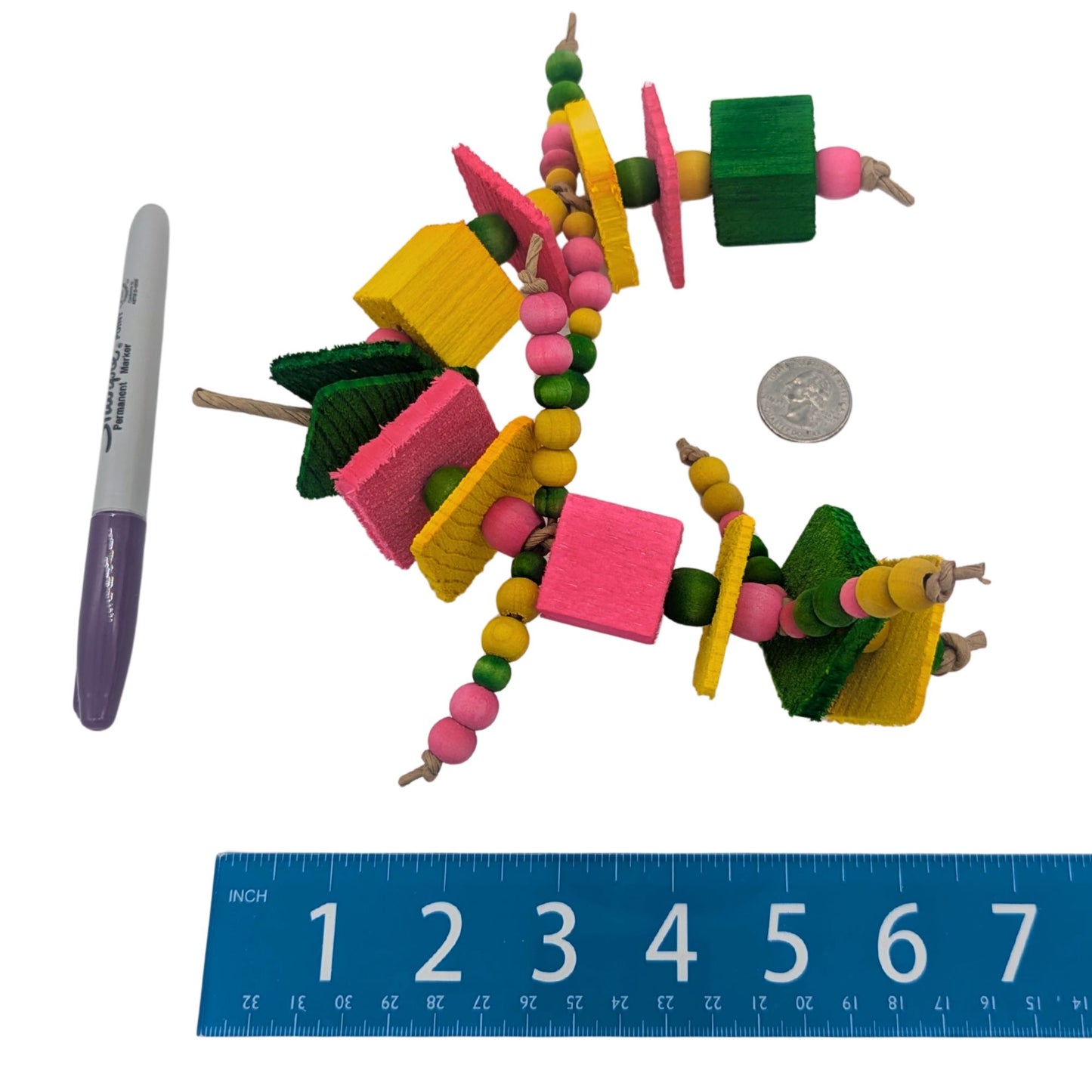 Triathlon by Lil Monsters Bird Toys. Shown next to a ruler, sharpie marker, and US quarter for scale. 