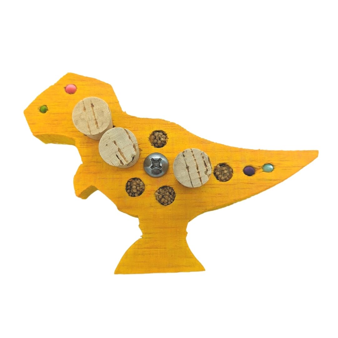 Balsasaurus Rex by Lil Monsters Bird Toys. A piece of balsa cut into the shape of a t-rex dinosaur. Embedded with cork stoppers and millet. Shown in a yellow color. 