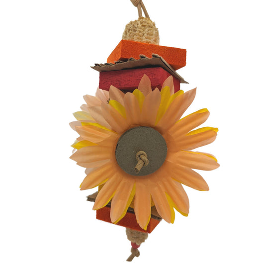 A balsa based bird toy with a sunflower made out of cupcake liners and cardboard circles. 