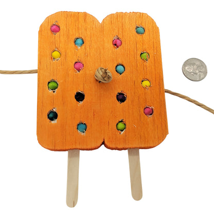 A twin popsicle shaped piece of balsa with popsicle sticks coming out the bottom, and paper rope through the middle. With embedded beads