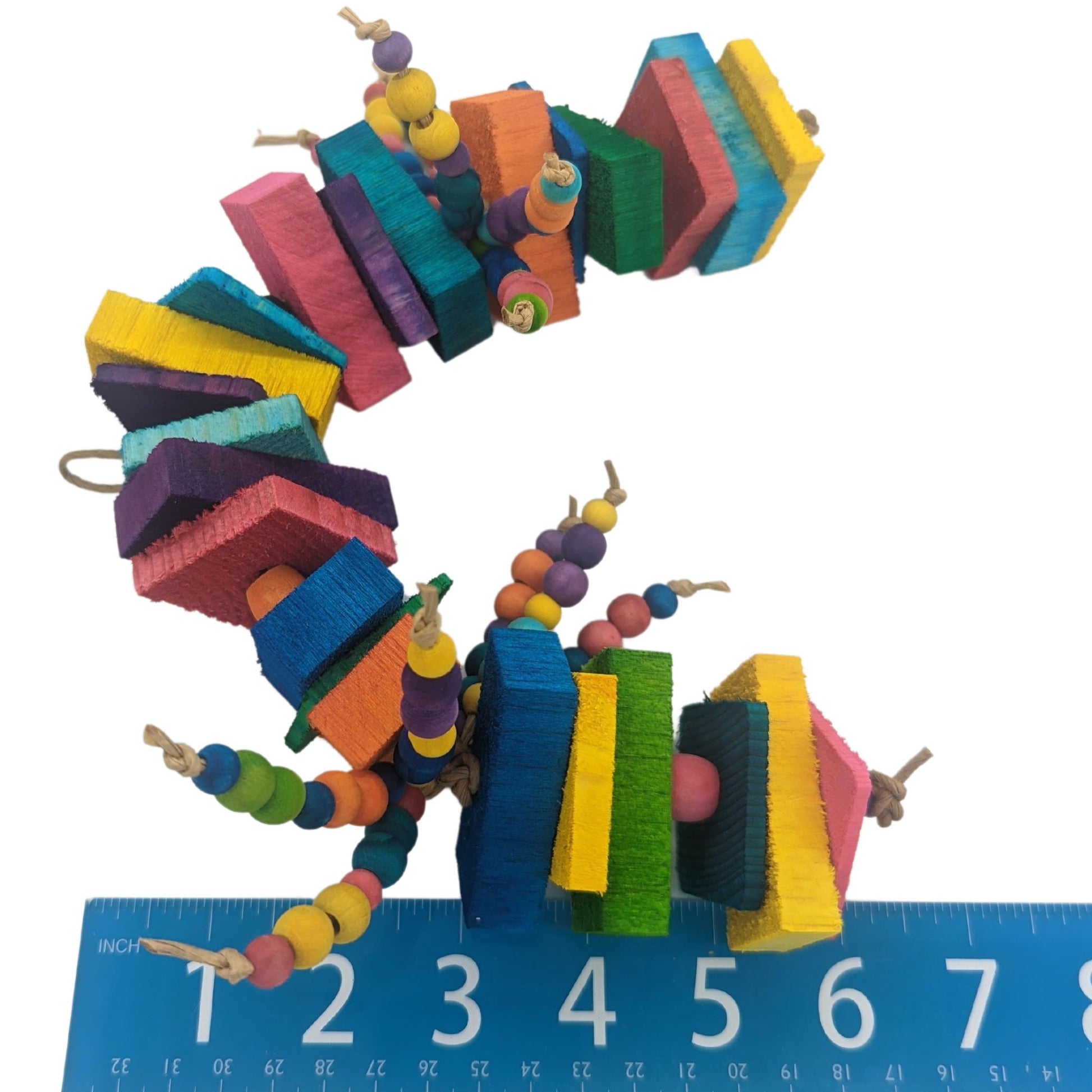 A brightly colored parrot toy. Has alternating sections of 1/4 inch and 1/8 inch thin pine with 1/2 inch balsa slats, separated by 1/2 inch wooden barrel beads. In the middle of the toy are two sections of 6 strands each of 8mm and 10mm wooden beads.