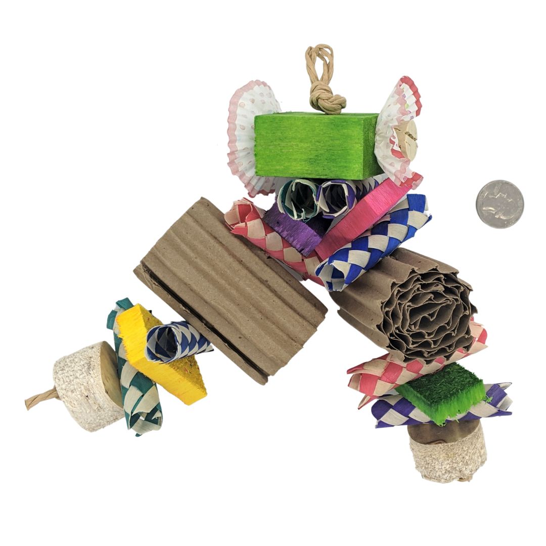 A parrot toy, with a 2 x 2 x 1 inch balsa block at the top. embedded with 2 cork stoppers and cupcake liners. From there on two strands, palm finger traps, half inch balsa slats, rolled corrugated cardboard, and finished with yucca chunks.