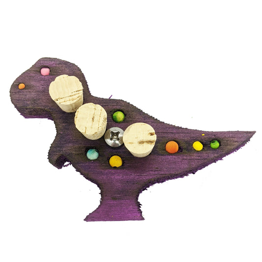 A tyrannosaurus rex shaped piece of balsa, with 4 small beads, 4 spots for millet or beads, and 3 cork stoppers.