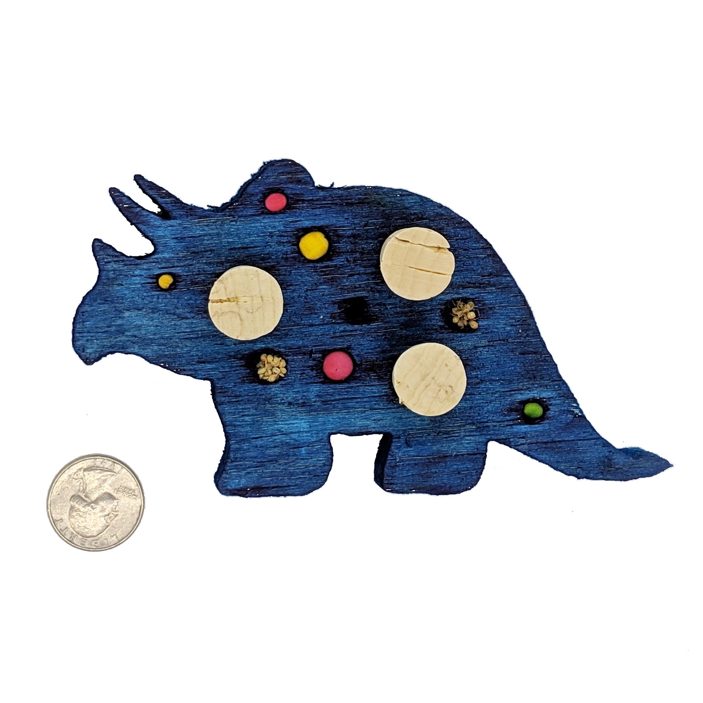 A triceratops shaped piece of balsa, with embedded corks, 4 spots for beads or millets, and 3 smaller beads. 