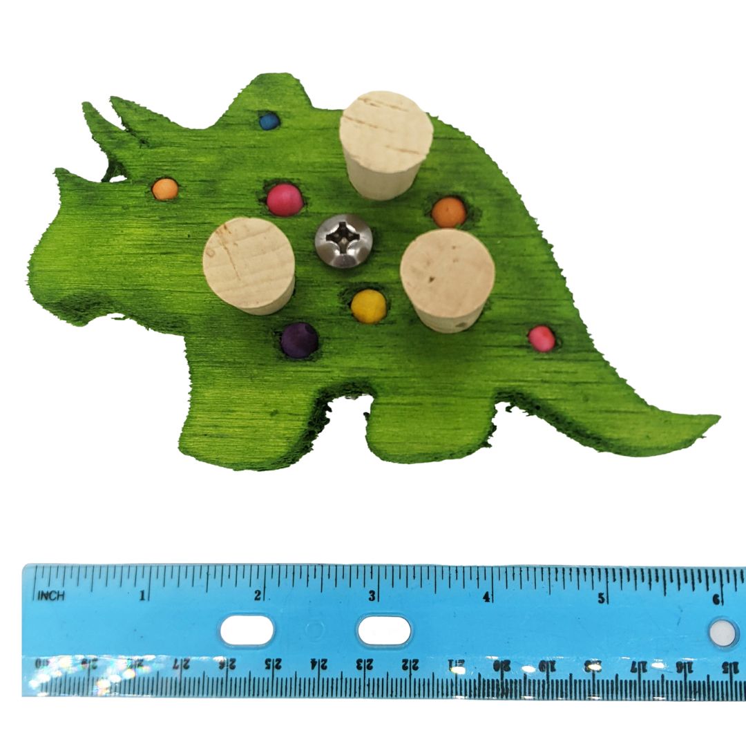A triceratops shaped piece of balsa, with embedded corks, 4 spots for beads or millets, and 3 smaller beads. Shown next to ruler to show 6" size