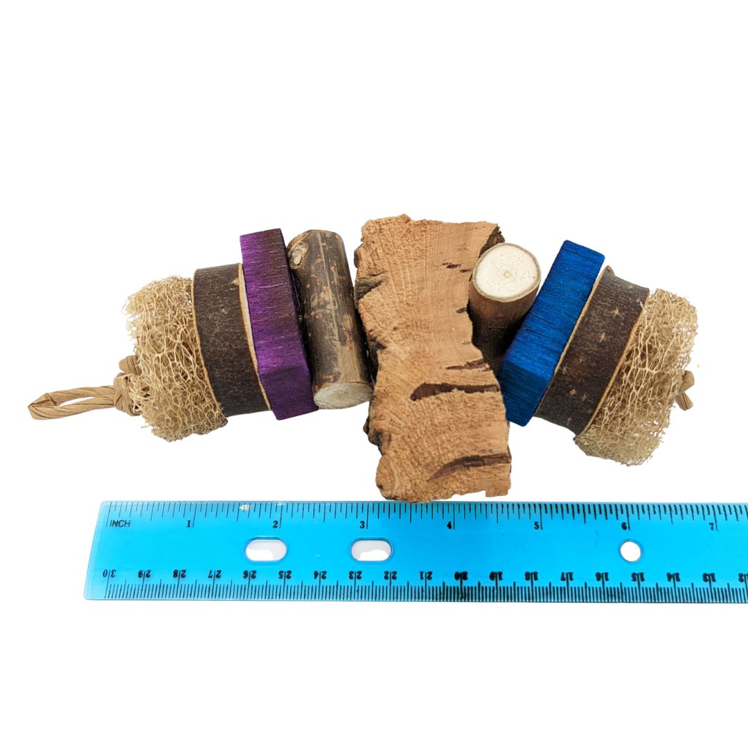 A parrot toy starting with loofah, cottonwood coin, balsa slat, cottonwood log, with a piece of cork bark before it repeats on the other side.