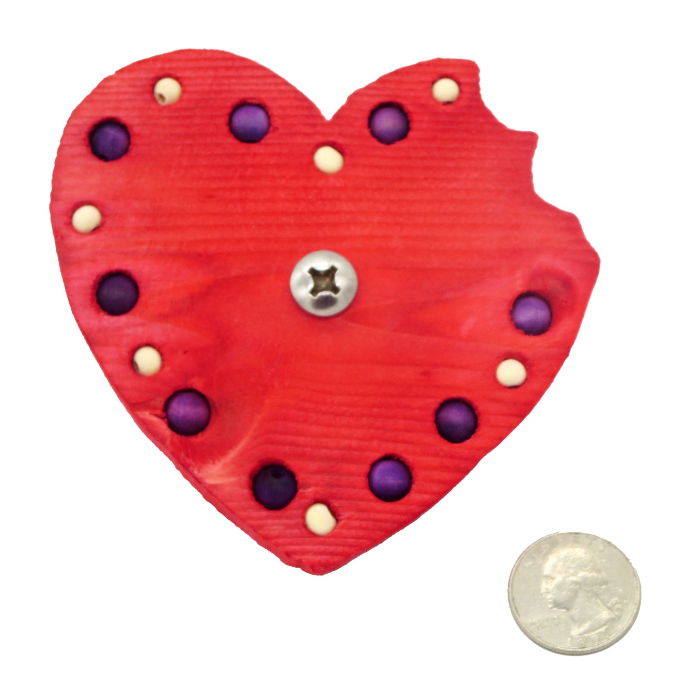 A heart shaped piece of pine with a "bite" taken out of the right lobe. Embedded with 8mm and 6mm beads around the border.  Shown with US quarter for scale