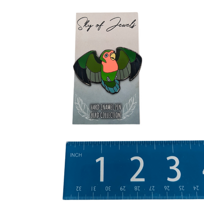 Lovebird Enamel Pin by Roamin Bison Workshop, on card and in hand for scale. Card mentions Sky of Jewels, Hard Enamel Pin Bird Collection. Next to Ruler for scale