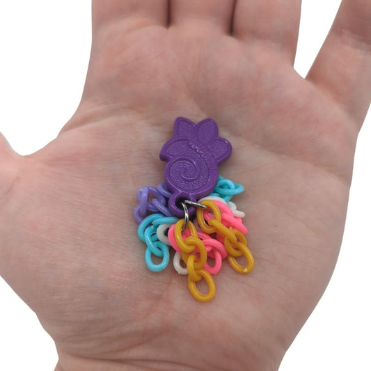 Tassels parrot foot toy by Tiny Conure Trinkets, in hand for scale