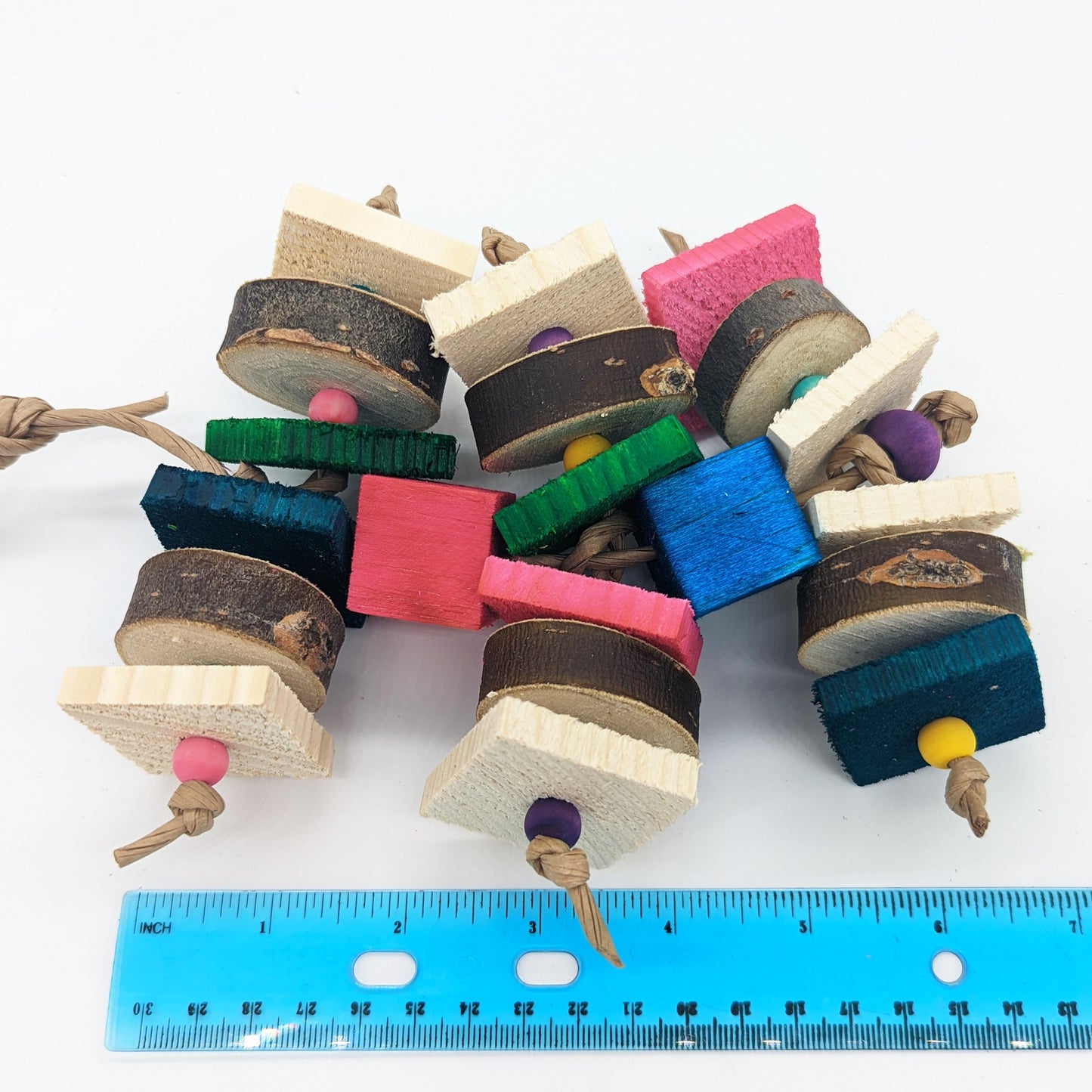 A bird toy for birds that love wood! Alternating pieces of 1/4" thin pine cut against the grain with pieces of natural willow or cottonwood slices. Wooden beads between the slices of wood, and balsa blocks between the levels of the toy.  Shown with a ruler to show its length of about 7". 