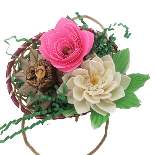 Wildflowers parrot toy for Lil Monsters Bird Toys, featuring flowers made of sola, paper, and palm, in a bamboo basket with shredded paper. 